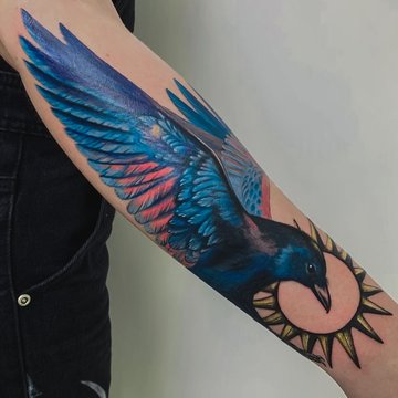 Яскраве тату птаха на передпліччі