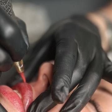 мастер делает перманентный макияж губ