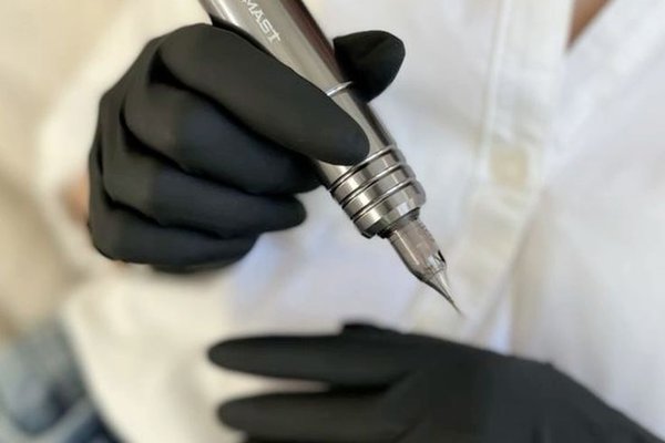 Майстер перманентного макіяжу тримає машинку